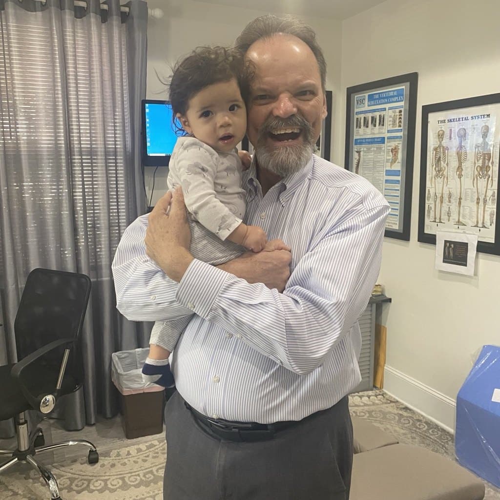 Dr. John Webster caring for an infant patient — family and pediatric chiropractic care